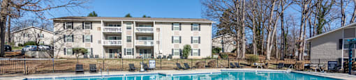 A large swimming pool in front of an apartment complex at Madison Woods apartments in Greensboro, NC.