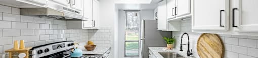 a kitchen with white cabinets and a stove and a sink