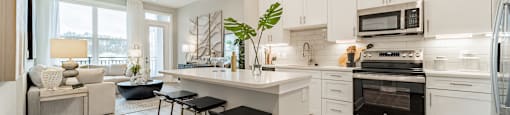A modern kitchen with white cabinets and a large island.