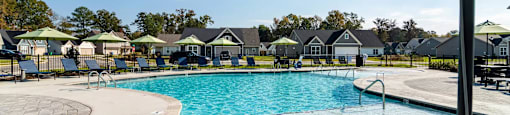 A pool with a green umbrella in the foreground.