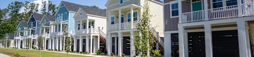 a row of town homes with lawns and trees in front of them