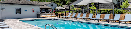 our resort style swimming pool is in front of our house with lounge chairs