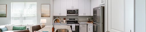an open kitchen and living room with a granite counter top