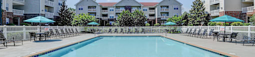 a swimming pool with apartment buildings in the background