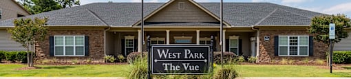 The entrance to West Park The Vue with a sign and two flags.