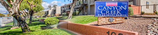 A sign for Canyon Creek is in front of a building.