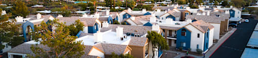 A sunset view of a neighborhood with houses and cars.
