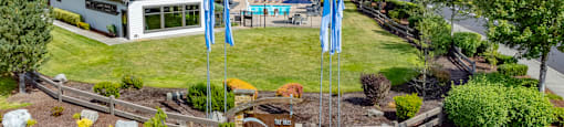 a backyard with blue flags and a house and a yard with a garden