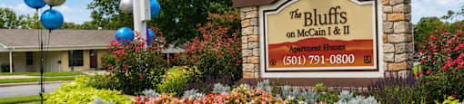 A sign for The Bluffs on McCain & II Apartment Homes with a phone number on it.