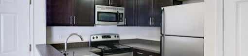 Stainless Steel Appliances With Dark Wood Cabinets  In Kitchen at Ponside at Littleton Apartments. at Pondside at Littleton, Massachusetts, 01460