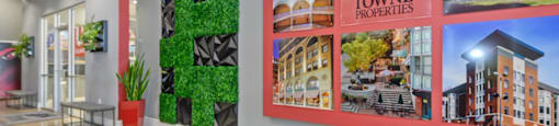 a lobby with a wall of pictures on the wall and a carpet on the floor