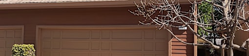 A brown house with a tan garage door.