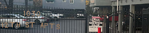 A parking lot with a sign that says "10-30" and a building in the background.