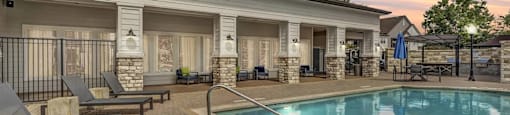 A poolside area with a building in the background.