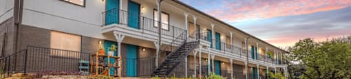 A building with a blue door and a balcony with a railing.