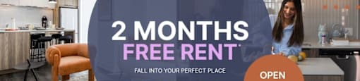 A woman stands in a kitchen with a sign offering 2 months free rent.
