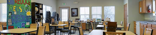 A room with tables and chairs and a sign that says Reduce, Reuse, Recycle.