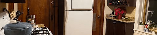 a kitchen with a white refrigerator and a stove