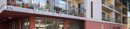 an apartment building with balconies and a sign in front of it