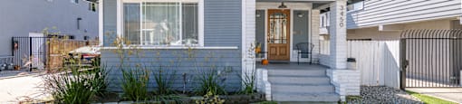 A house with a grey front and a white door.