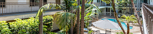 a patio with palm trees and a table and chairs