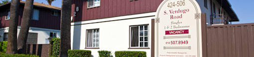 a red and white house with a sign in front of it