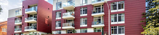 a red apartment building on the corner of a street