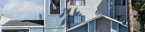 A blue house with a sign that says "Now Leasing".