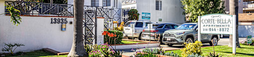 A white building with a sign that says Corte Bella in front of it.