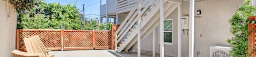 the patio of a house with stairs and a wooden bench