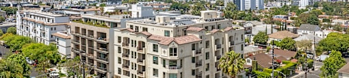 A large apartment building with a parking lot in front of it.
