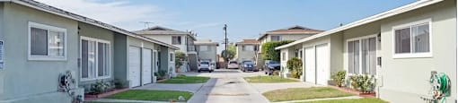 a row of houses on a street with a clear blue sky in the background