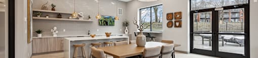 the gathering room and kitchen of a home with a dining table and chairs