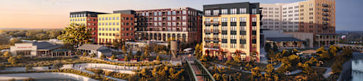 A modern building complex with a bridge over a body of water.