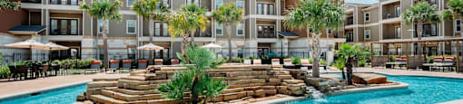 a swimming pool with palm trees in front of an apartment building