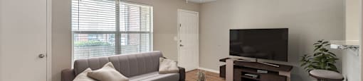 an empty living room with a couch and a tv