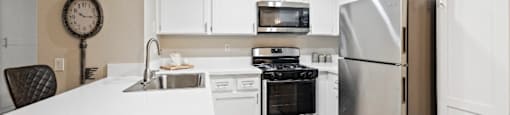 A modern kitchen with a white countertop and stainless steel appliances. at The Oaks Apartments, California, 91786