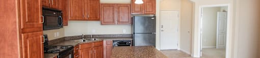 a kitchen with wood cabinets and black appliances