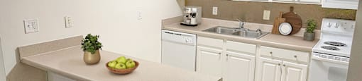 a kitchen with white cabinets and a counter with two stools