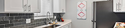 a kitchen with white cabinets and a stainless steel refrigerator