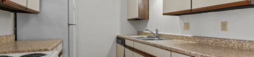 an empty kitchen with white appliances and granite counter tops