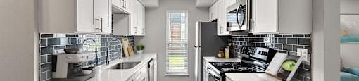 A modern kitchen with white cabinets and appliances.
