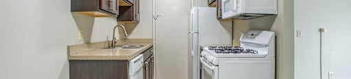 A kitchen with white appliances and wooden cabinets.