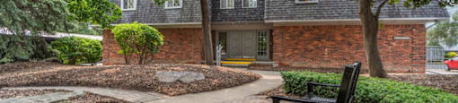 a brick house with a brick walkway and a bench