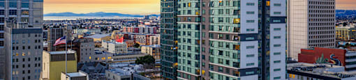 A cityscape with buildings and a sunset.