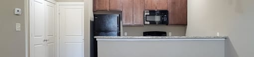 Modern kitchen with granite countertop and wood cabinets at City Place Apartments, Texas