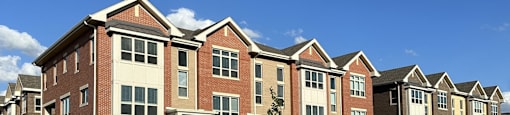 a row of brick apartment buildings on the side of a street
