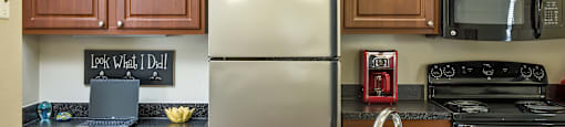 a kitchen with a granite counter top and a stainless steel refrigerator