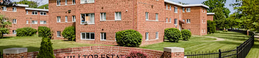a large brick building with a black fence in front of it