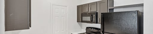 Kitchen with sleek black appliances at Bonito Parque Apartments in San Antonio TX